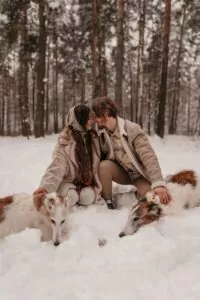 A Romantic Couple with Their Pets in the Snow